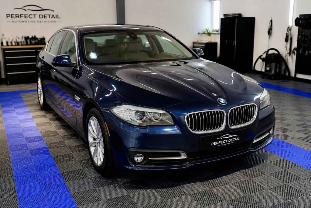 Granatowe BMW serii 5 w profesjonalnym studiu detailingu samochodowego